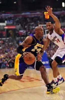 A couple of men playing basketball on a court.