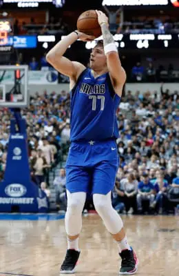 A man in blue and white playing basketball.