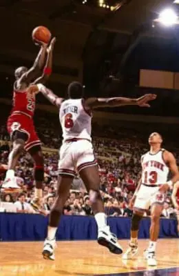 A group of men playing basketball on a court.