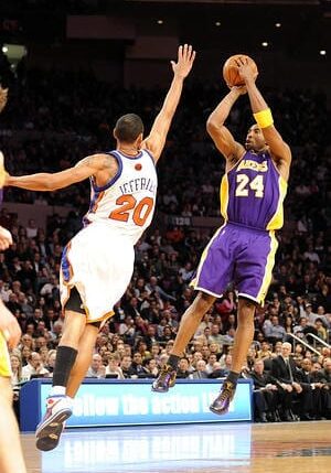 A basketball player is jumping to hit the ball.