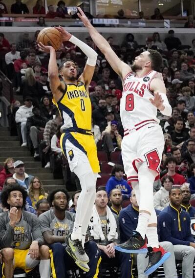 A couple of men playing basketball on a court.