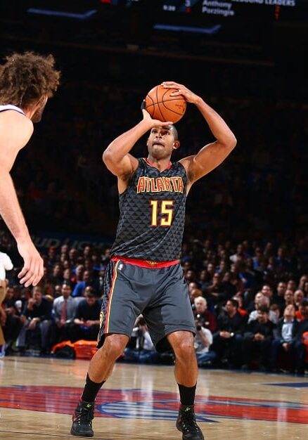 A man holding a basketball up to the air.