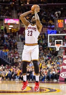 A man that is jumping in the air with a basketball.